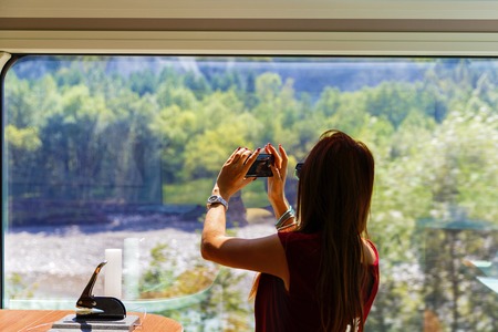 female tourist takes pictures from a window at the landscapeの写真素材
