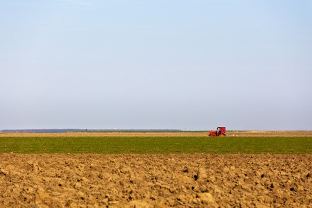 agricultural equipment in the field doing work springの写真素材