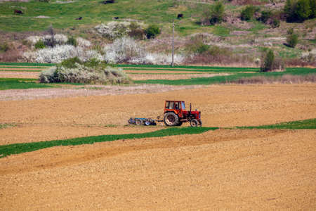 tractor working in a field at springの写真素材