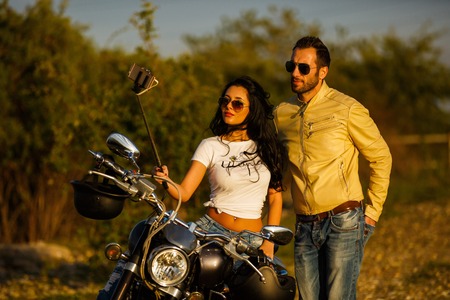 Beautiful young couple with a classic motorcycleの写真素材