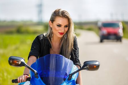 Portrait of a beautiful woman and a motorcycle of speedの写真素材
