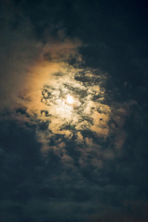 Moon among the clouds in the eveningの写真素材