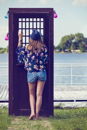 Portrait with a woman at a door near the lakeの写真素材