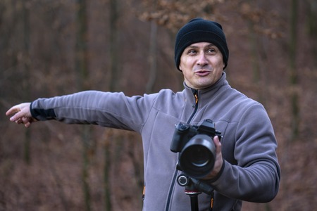 Photographer with professional camera taking pictures outdoorの写真素材