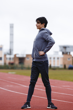 young sportsman makes exercises on a running trackの写真素材