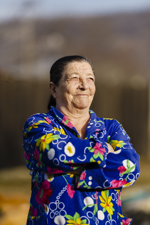 Old woman outdoor in her backyard, closeup portraitの写真素材