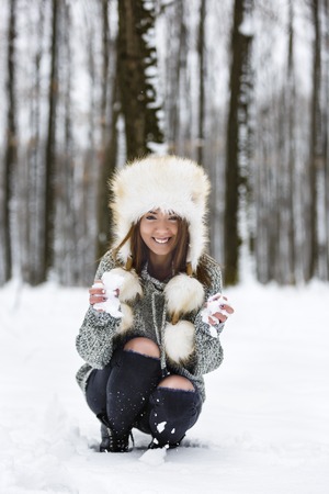 beautiful young woman enjoying winter in the woodsの写真素材