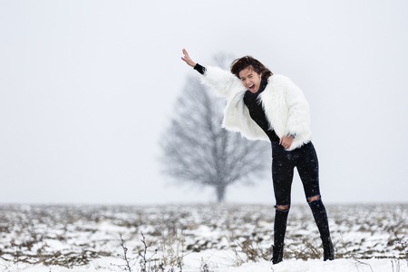 beautiful young woman enjoying winter in the woodsの写真素材