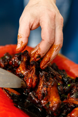 Man washing chicken drumsticks under tap water in the kitchenの写真素材