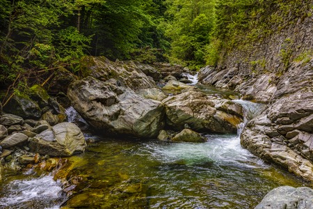 a beautiful mountain river among the rocks with crystal waterの写真素材