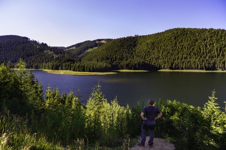 tourist looking Vidra dam lake in Parang mountainsの写真素材