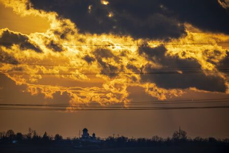 Sky at sunset with dark clouds and sun behindの写真素材