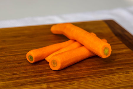 freshly picked, washed carrots,  on a wood cutting board