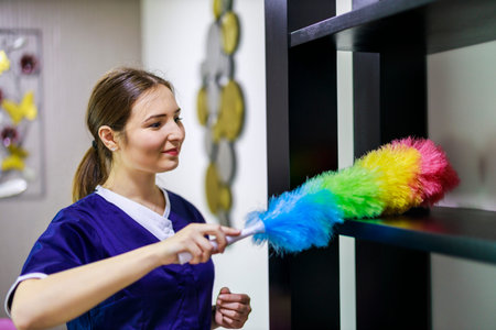 Cleaning service. Cleaning woman. Woman hold colorful dusting brush. Grill cleaner with uniform