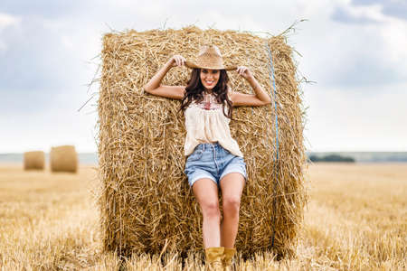 Beautiful cowboy woman Posing near at the haystacks, Fashion concept.の写真素材