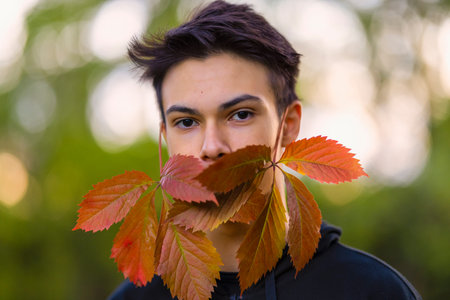 Young handsome man outdoors in fall clothing with autumn natural surroundings
