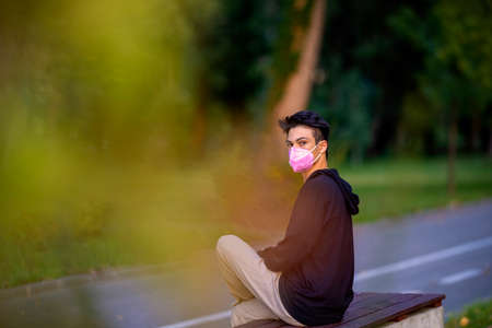 Young handsome man outdoors in fall clothing with autumn natural surroundingsの写真素材