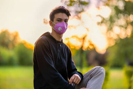 Young Man in the Flu Mask in the Autumn Parkの写真素材
