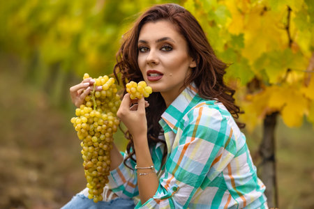 Smiling woman with basket of grapes in the vineyard