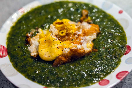 Nettle cream soup with fried eggs on top, homemade.の写真素材