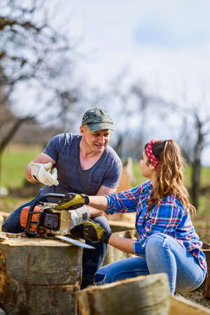 Lumberjack teaches his apprentice how to use the chainsawの写真素材