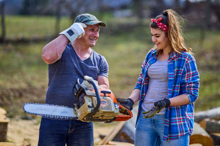 Lumberjack teaches his apprentice how to use the chainsawの写真素材