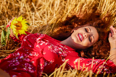 a beautiful woman in a wheat field on a sunny summer dayの写真素材