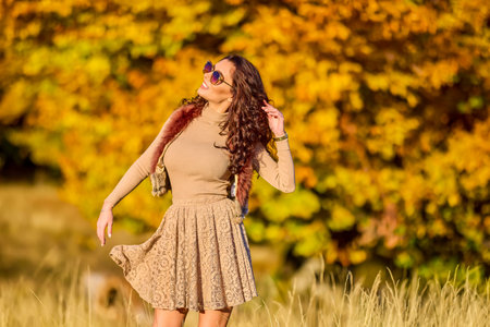 a beautiful elegant woman posing on a sunny autumn day.の写真素材