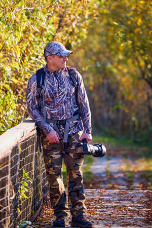 a professional willife photographer in camouflage outfit
