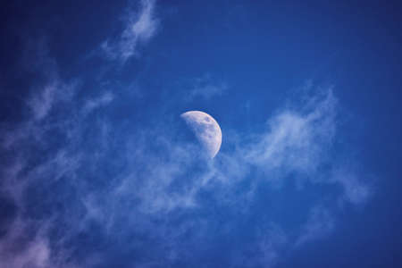 the moon in the blue sky with clouds at duskの写真素材