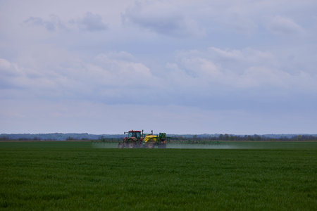 a tractor that herbicides a wheat cropの写真素材