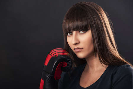 portrait of a boxer woman with a boxing glove near her faceの写真素材