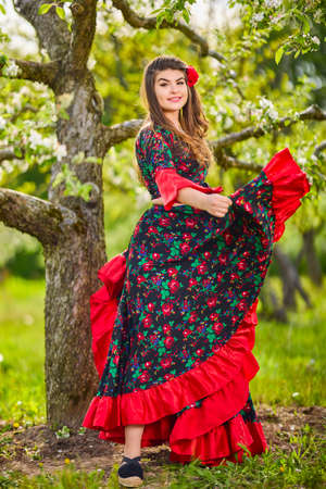 beautiful woman in traditional gypsy dress posing in nature in springの写真素材