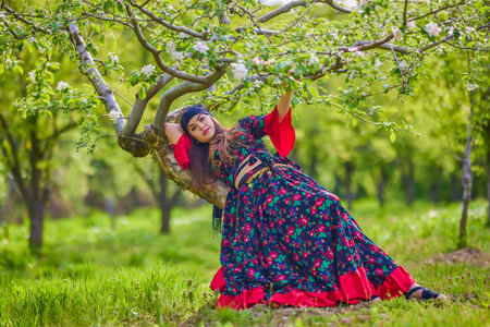 beautiful woman in traditional gypsy dress posing in nature in spring