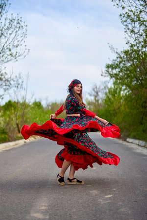 beautiful woman in traditional gypsy dress posing in nature in springの写真素材