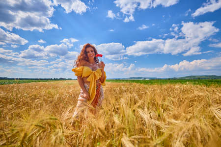 A happy caucasian young and beautiful woman in a field.の写真素材