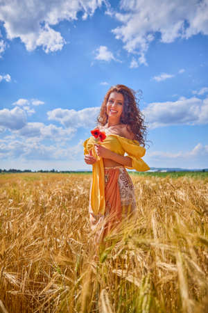 A happy caucasian young and beautiful woman in a field.の写真素材