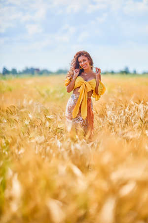 A happy caucasian young and beautiful woman in a field.の写真素材