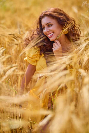 A happy caucasian young and beautiful woman in a field.の写真素材