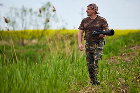 A professional photographer taking pictures of a flowering rapeseed fieldの写真素材