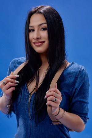 a young brunette with long hair posing in the studio with a backpack, Back to school concept.