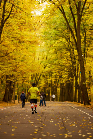 Portrait of a middle-aged man running in the park on an autumn day.