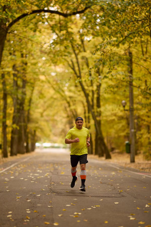 Portrait of a middle-aged man running in the park on an autumn day.の写真素材