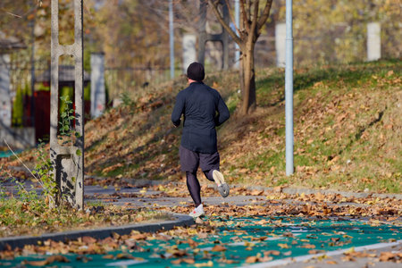 Portrait of a middle-aged man running in the park on an autumn day.