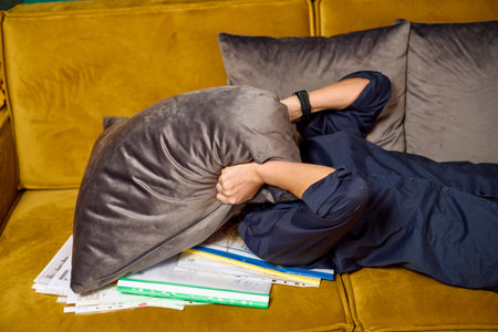 Businesswoman standing exhausted from work on a couch near Files.