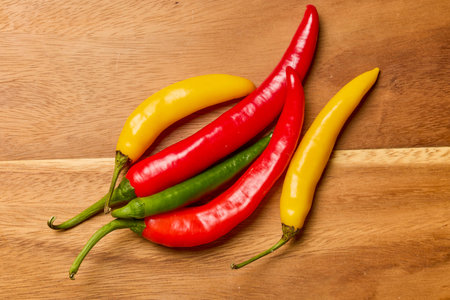 Hot peppers of different colors on a wooden chopper