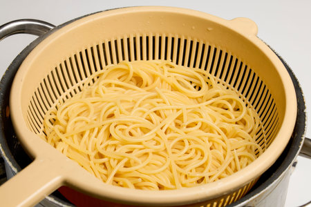 cooked spaghetti drained in a sieve.