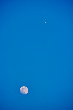 landscape with the moon and an airplane in the blue skyの写真素材