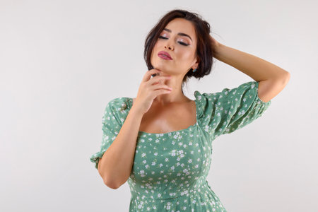 portrait of a beautiful woman with long black hair posing in studio on gray background.の写真素材