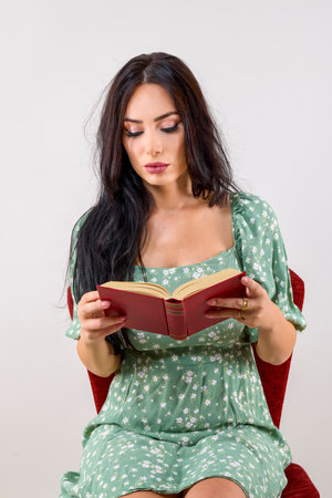 portrait of a beautiful woman with long hair reading a book.の写真素材